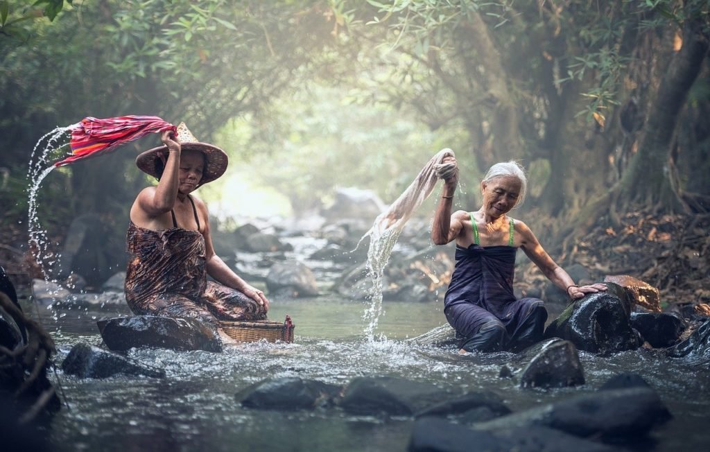 Hand washing clothes in the river